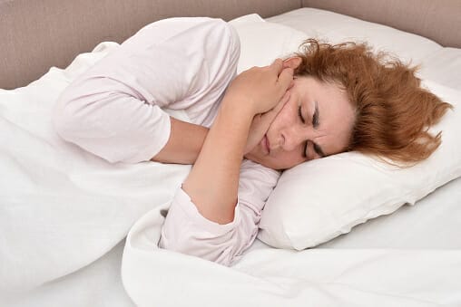 Woman In Bed With Toothache